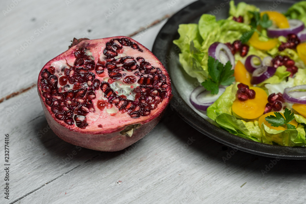 Healthy breakfast, fresh salad with the addition of purple onion and pomegranate seeds on white, wooden background Healthy breakfast, fresh salad with the addition of purple onion and pomegranate seeds on white, wooden background