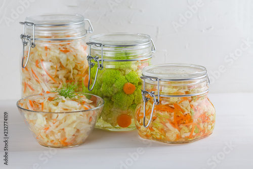 Fermented preserved vegetarian food concept. Cabbage, broccoli, caulie, sauerkraut sour glass jars on white background