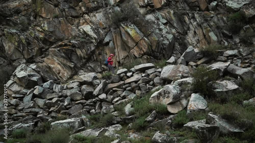 tourist woman in cap with backpack climbing stones mountains 50 fps