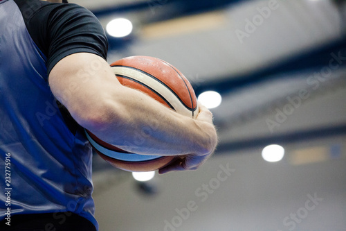 A referee holds a basketball during a basketball game. Judge a match © Lidia_Lo