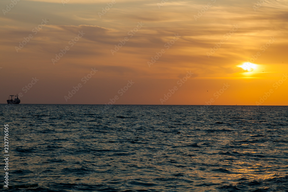 landscape sea with waves and sunset sky with a ship