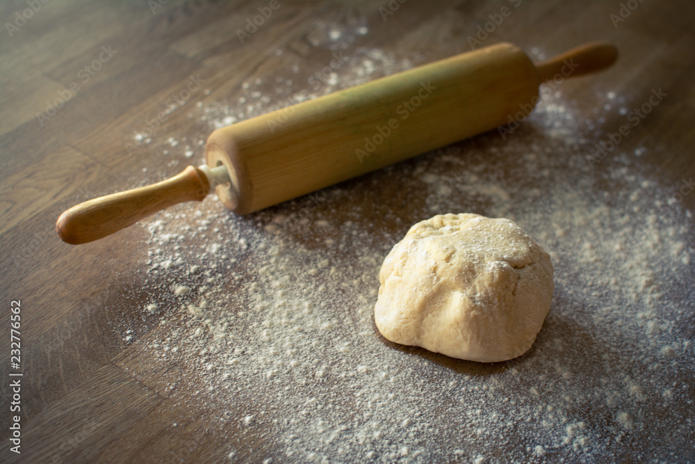 Pie dough and rolling pin on a wooden table covered with flour Pie dough and rolling pin on a wooden table covered with flour