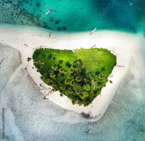 Aerial top down photo of a beautiful small beach island with white sand and clear blue turquoise water photo