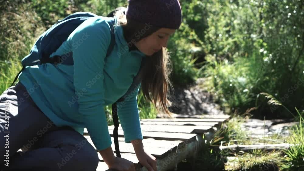 young woman tourist drink water, wets hands in a mountain river. Slider 50 fps young woman tourist drink water, wets hands in a mountain river. Slider 50 fps