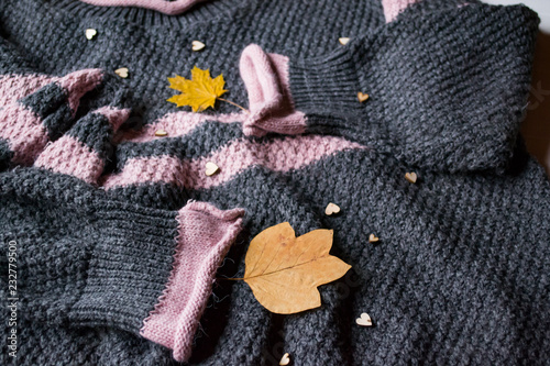 Women's sweater decorated with autumn leaves. Sweater texture. Cold season.