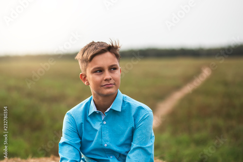 portrait of a cute teen boy in summer in nature