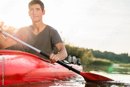 Portrait of a man kayaking using paddle on idyllic lake