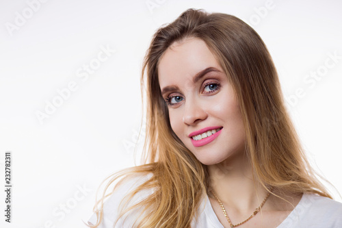 Close-up portrait of beautiful happy young woman with blonde hair and looking at camera on white background
