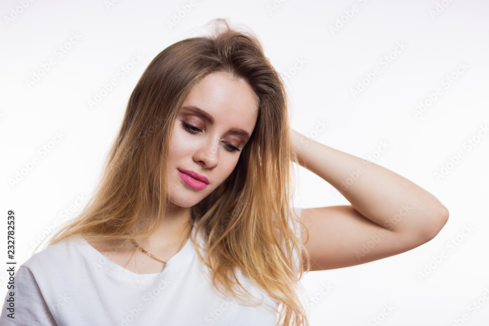 Horizontal close-up portrait of beautiful blonde woman looking down on white background Horizontal close-up portrait of beautiful blonde woman looking down on white background