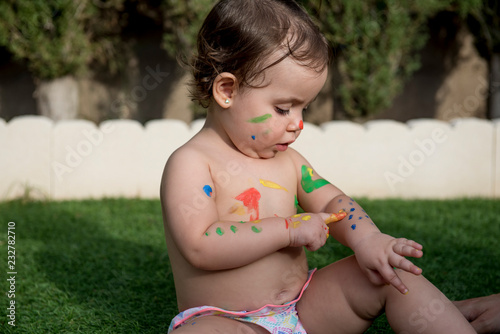 Pretty baby smeared with paints