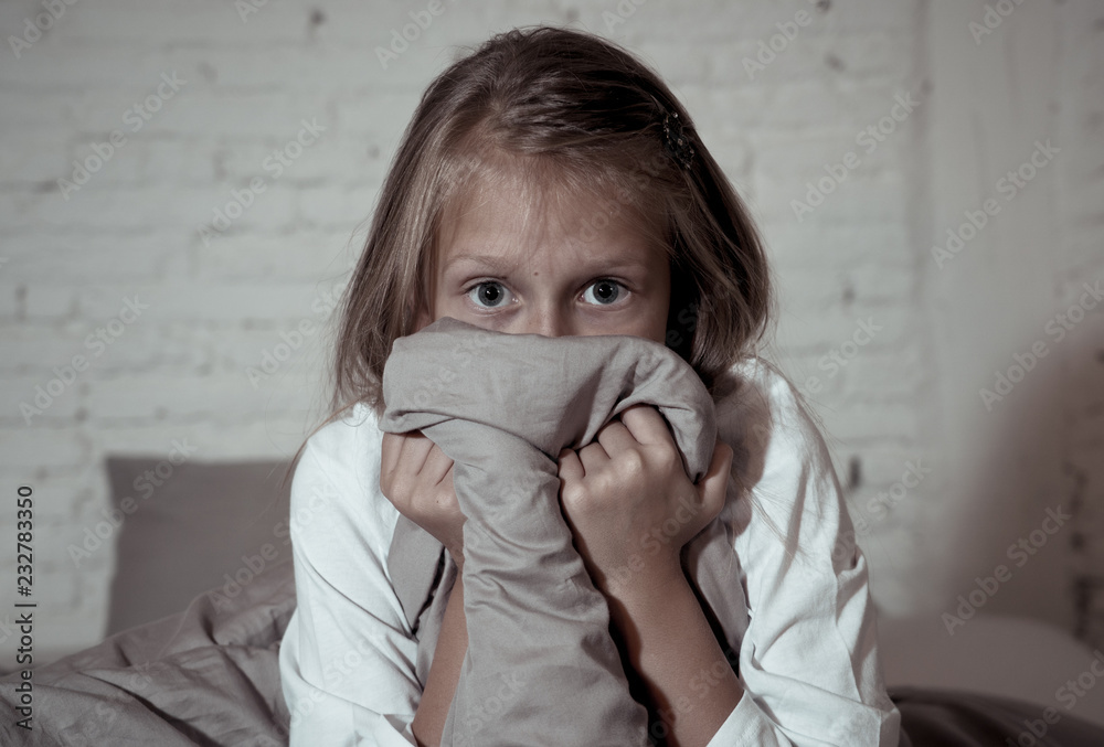 Sleepless cute girl in fear at night hiding behind the blanket afraid of dark and monsters Sleepless cute girl in fear at night hiding behind the blanket afraid of dark and monsters