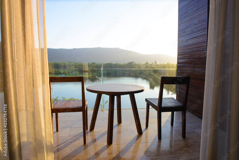 Balcony of house lake view with wooden table and chair