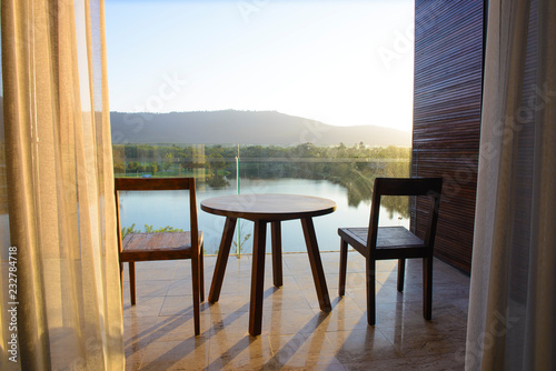 Balcony of house lake view with wooden table and chair