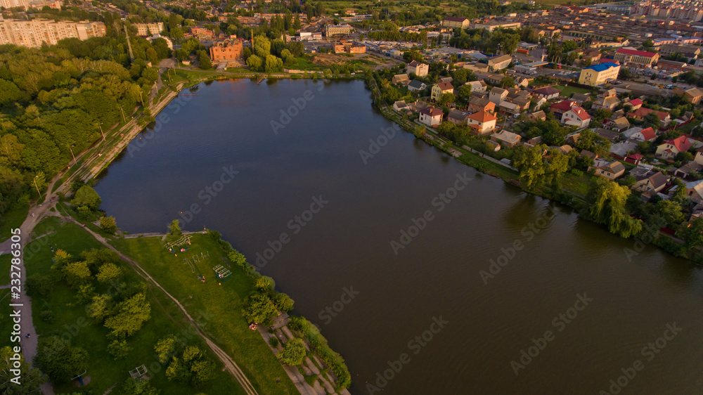 Aerial view of the summer city park near the lake. Beautiful view of nature.