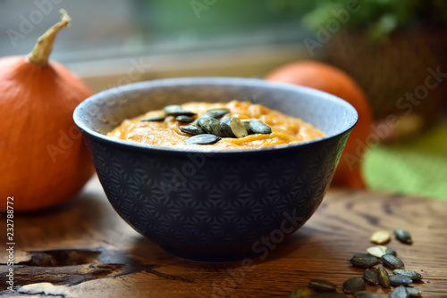 délicieuse soupe de potiron jaune aromatique servie dans un bol en céramique bleu foncé photo