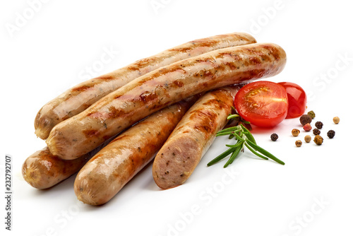 Grilled Nuremberg Sausages with herbs, pepper and tomatoes, isolated on a white background. Close-up.