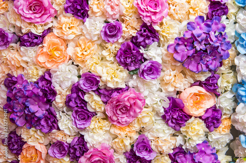 Beautiful multicolored artificial flowers background. flowers decor.