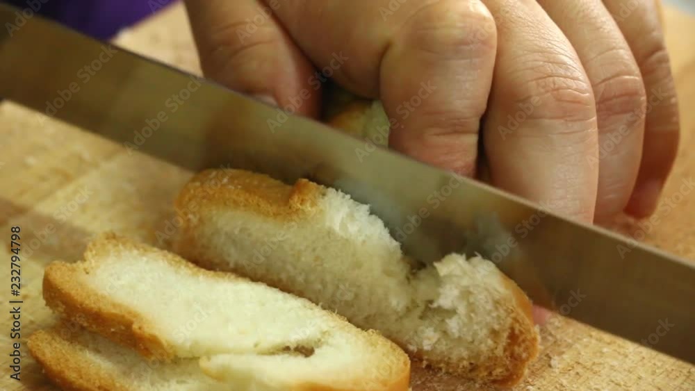 Chef  cutting bread by bread knife 
