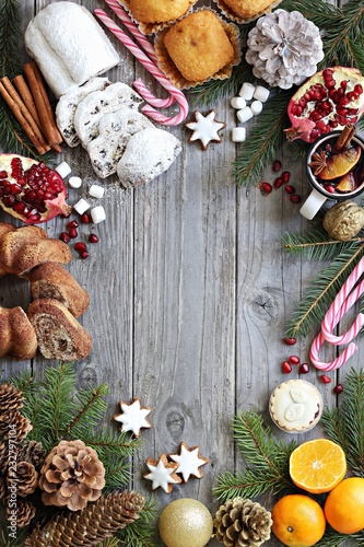 Christmas background with stollen cake, traditional sweets and festive decoration. Overhead view, copy space