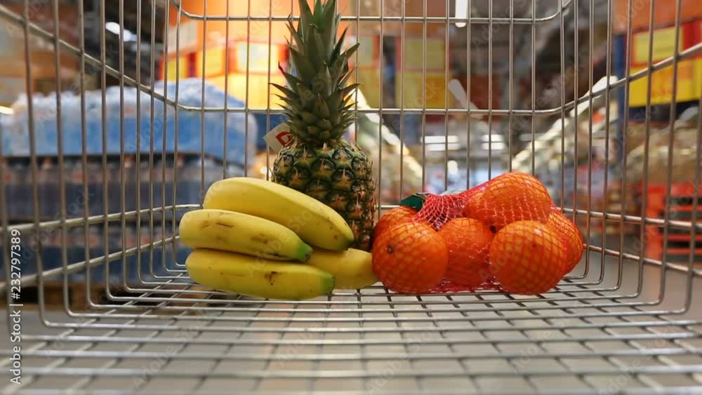 Time lapse of shopping cart with fruits moving through supermarket
