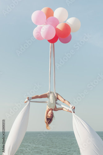 Girl acrobat doing splits in the air.