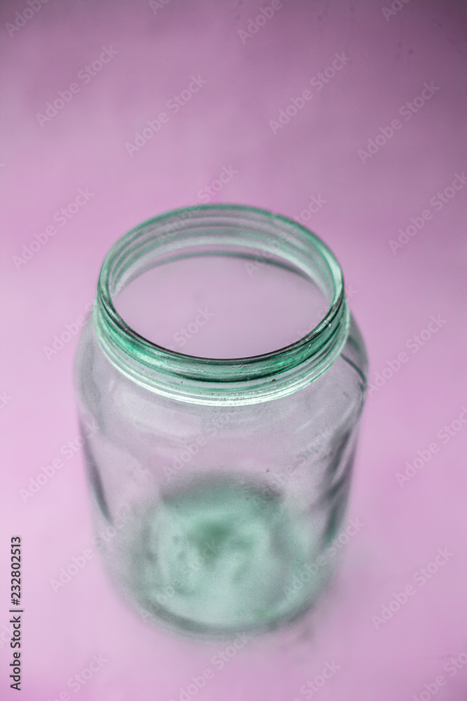 Close up of empty glass jar or storage jar or glass container isolated on pink surface. Close up of empty glass jar or storage jar or glass container isolated on pink surface.