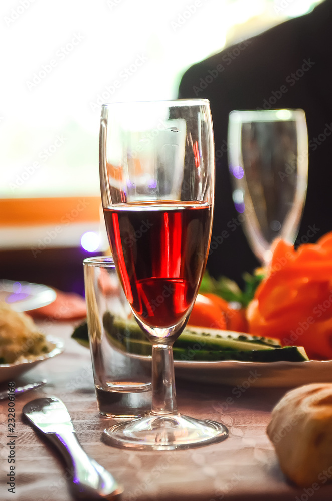 A glass of red wine is on the table. A glass of red wine is on the table.