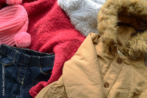 Background with warm baby sweaters. Pile of clothes warm background. Autumn winter concept.
