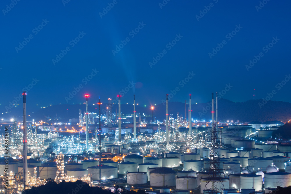 The Oil refinery  industrial with Tank farm manufacturing near sea port at night in blue tone and leaving top space, Location on Laemchabang, Chonburi, Thailand. 