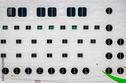 The side of a cruise ferry in the harbor of Kiel. Many windows of the hotel rooms on a floating city. A cruise ship is a supersized pollution problem.