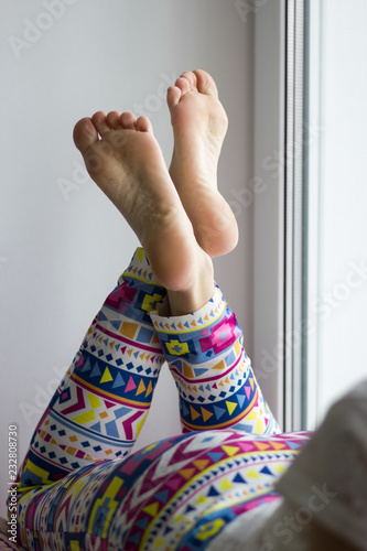 Sexy and beautiful female soles and feet crossed on windowsill photo