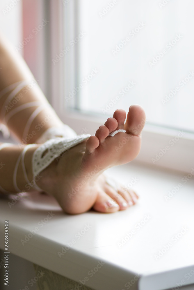 Young female sits on the window background. Feet, soles and toes close-up  Stock Photo