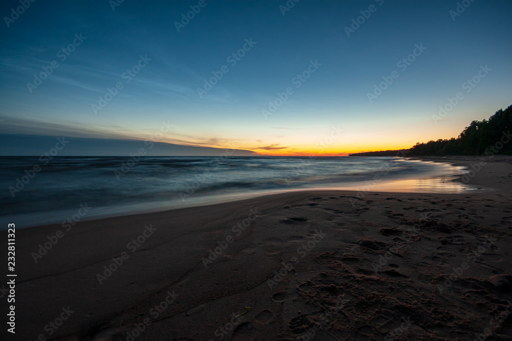 long exposure sea beach with rocks and washed out waves of water