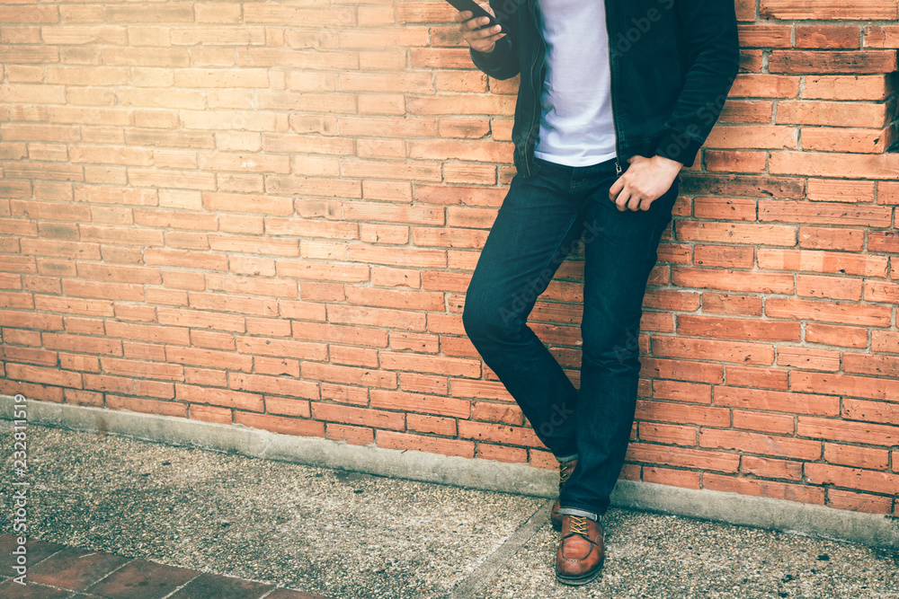 Smart man standing front a wall background. Smart man standing front a wall background.