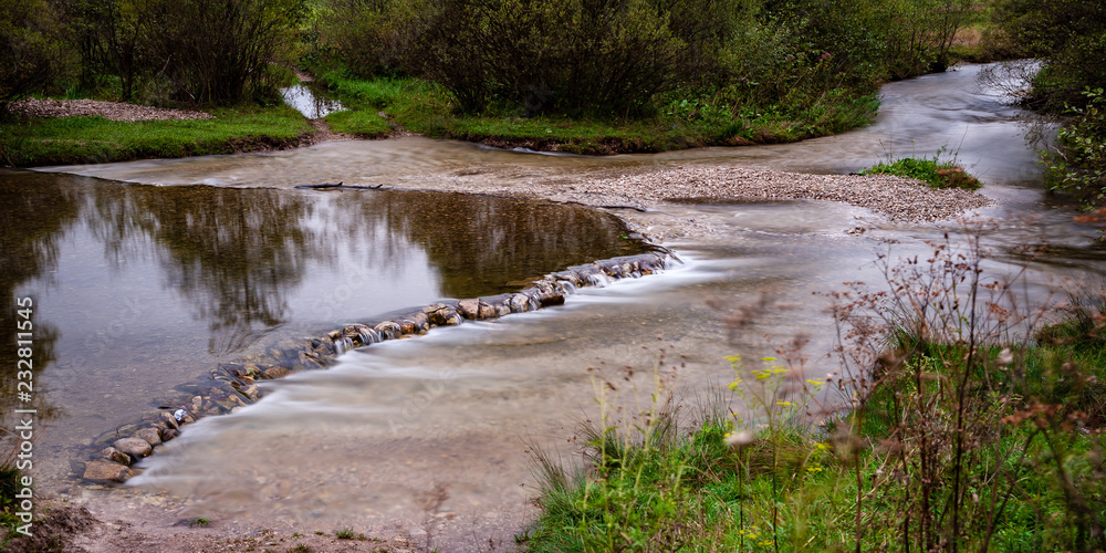 long exposure rocky mountain river in summer with high water stream level long exposure rocky mountain river in summer with high water stream level