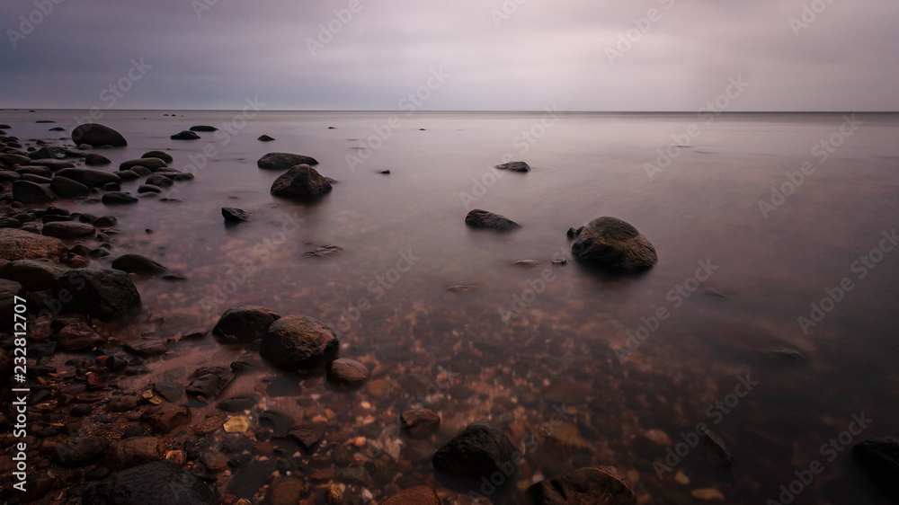 long exposure sea beach with rocks and washed out waves of water long exposure sea beach with rocks and washed out waves of water