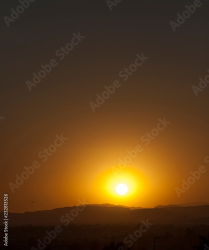 Sunset on the background of mountains and flying plane, Alicante city, Spain photo