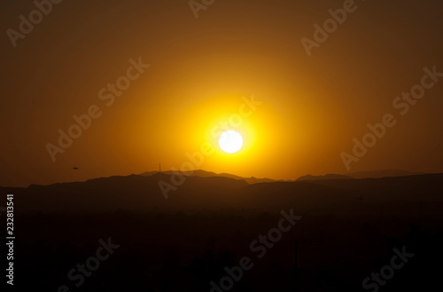 Sunset on the background of mountains and flying plane, Alicante city, Spain photo