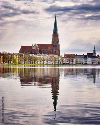 Clouds and cathedral in the old town of Schwerin are reflected in the lake Pfaffenteich.