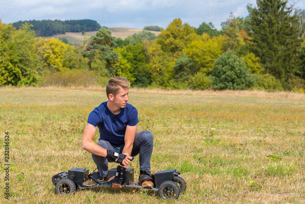 Young dutch man rides electric mountainboard off road