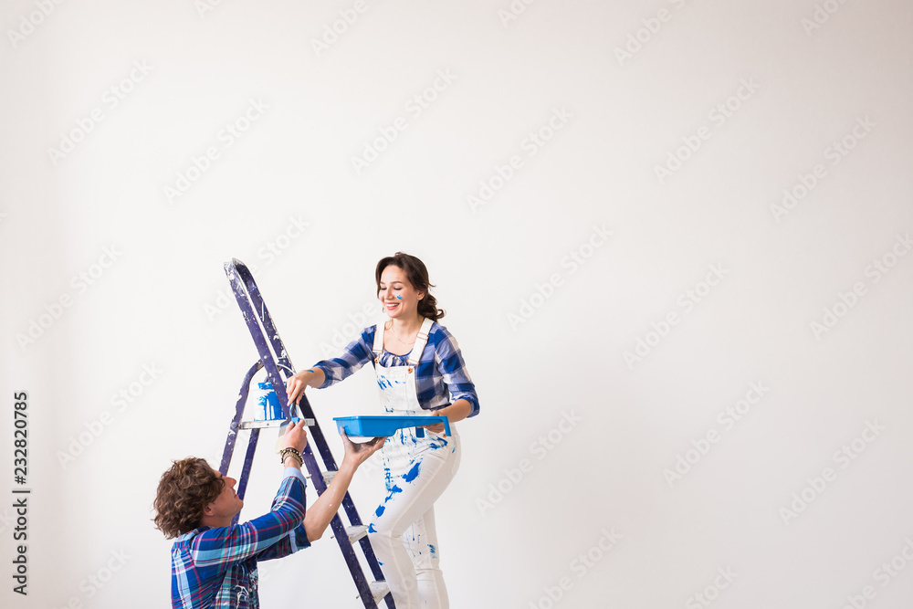 Teamwork, renovation and repair concept - Portrait of funny couple doing redecoration in apartment with copy space Teamwork, renovation and repair concept - Portrait of funny couple doing redecoration in apartment with copy space