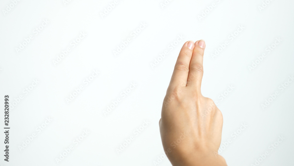 Close up of isolated female hand shows two fingers up isolated on white background Close up of isolated female hand shows two fingers up isolated on white background