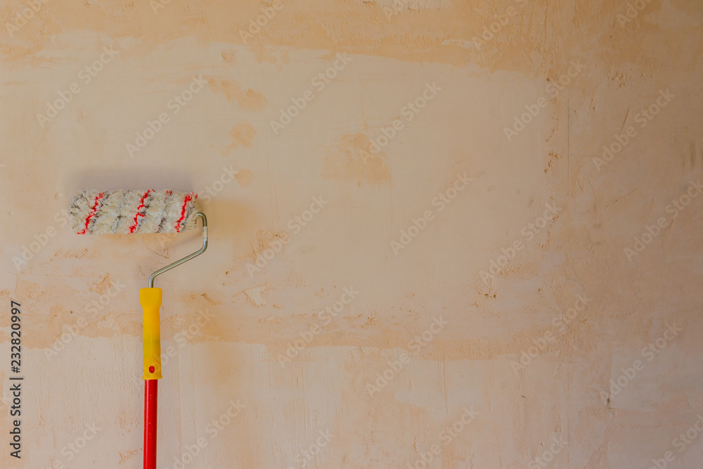 Used roller paint brush on light beige concrete background Used roller paint brush on light beige concrete background