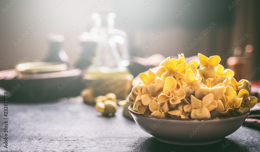 Bowl with fresh homemade tortellini on dark rustic kitchen table , front view. Home cuisine Bowl with fresh homemade tortellini on dark rustic kitchen table , front view. Home cuisine