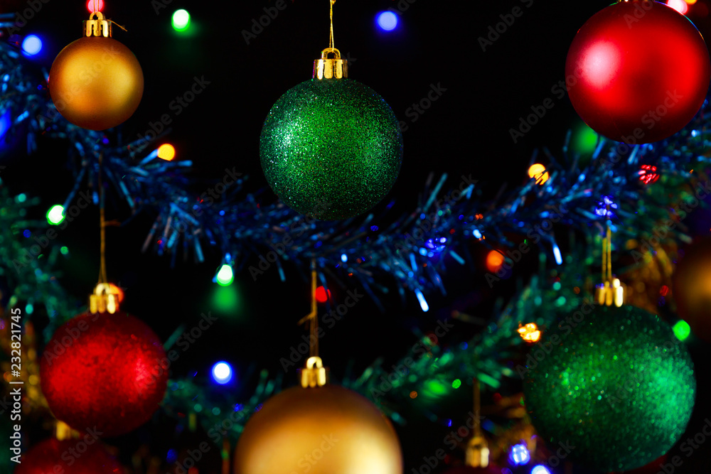 Close up of hanging Christmas decorations against a black background. Close up of hanging Christmas decorations against a black background.