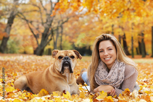 Cute continental bulldog lying  in autumn with its owner  on the ground photo