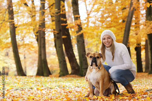 Attractive woman sitting with her dog in autumn surrondings photo