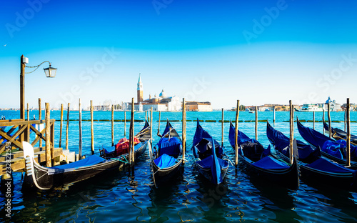 view of San Giorgio island with row of Gondola boats, Venice Italy, retro toned © neirfy