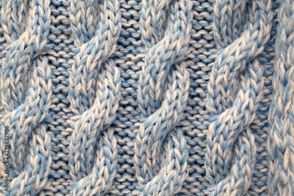 Knitted fabric with a pattern. Yarn texture background, warm clothing, crocheting concept