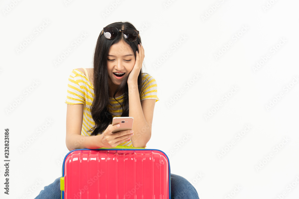 Beautiful young woman smiling and pulling pink color luggage isolated on white background.Woman going to summer vacation.Travel trip funny... Beautiful young woman smiling and pulling pink color luggage isolated on white background.Woman going to summer vacation.Travel trip funny...